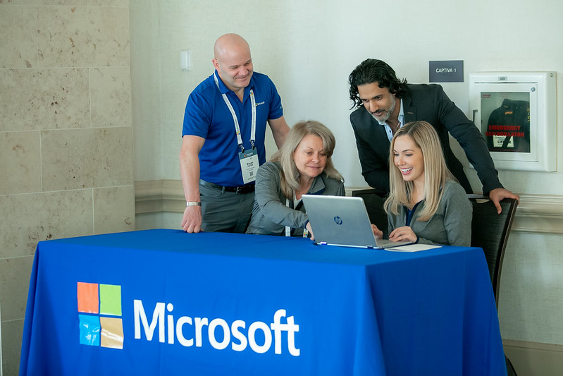 People at table with Microsoft Logo