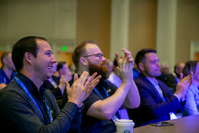 Conference attendees clapping during a session